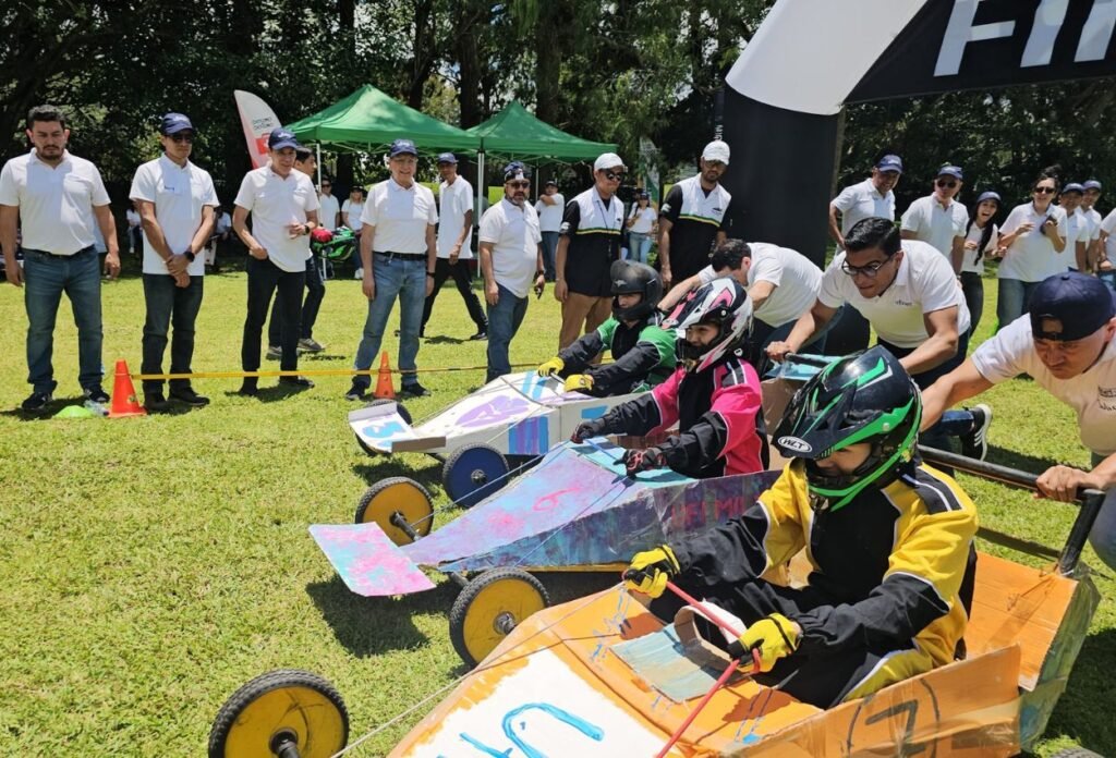 Colaboradores empujando carritos de carrera artesanales en una dinámica de team building de Extremo a Extremo en Guatemala