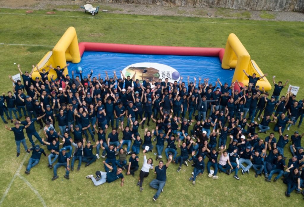 Vista aérea de un grupo corporativo celebrando junto a una cancha inflable en un evento de Extremo a Extremo