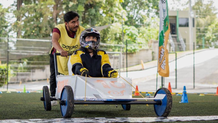 Colaborador con casco al volante del vehículo de su escudería en pista