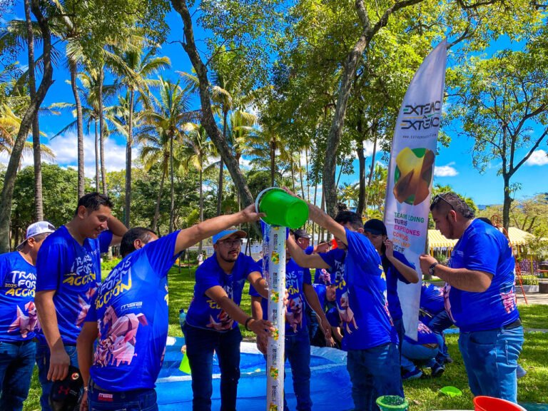 Participantes llenando un tubo con agua en una actividad de team building acuático