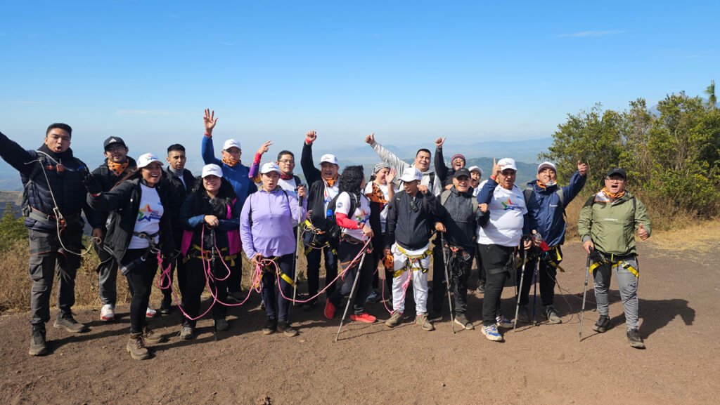 Colaboradores levantando los brazos durante caminata corporativa en el Volcán de Pacaya