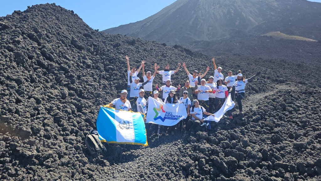 Grupo de colaboradores celebrando juntos durante experiencia de integración en el Volcán de Pacaya